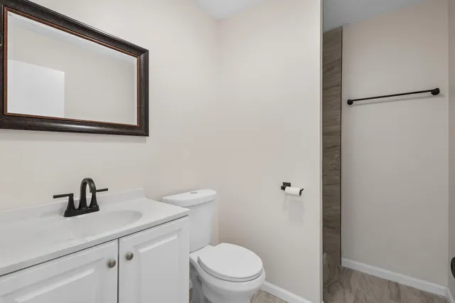 a bathroom with a toilet a sink and mirror