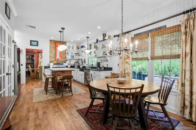 a dining room with furniture a chandelier and wooden floor