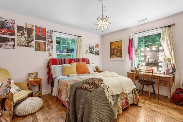 a bedroom with bed a two couches and a large window