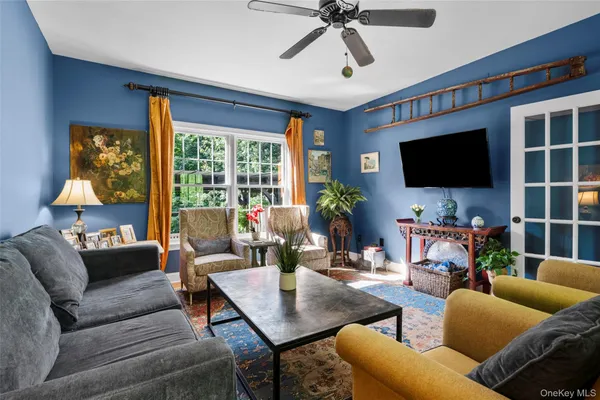 a living room with furniture a flat screen tv and a large window
