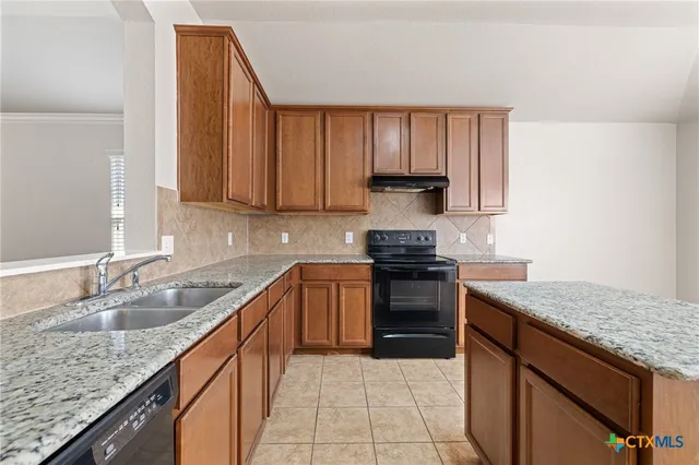 a kitchen with stainless steel appliances granite countertop a sink stove and cabinets