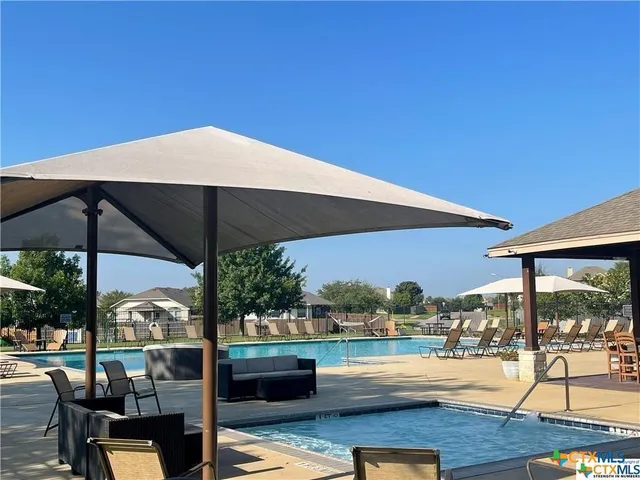 a front view of a house with a yard and potted plants
