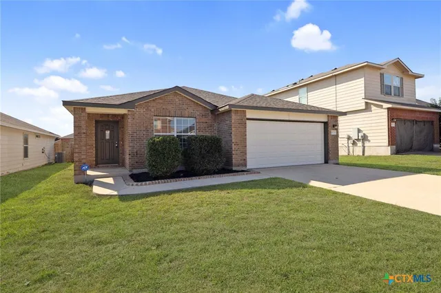 a view of a house with a yard and garage