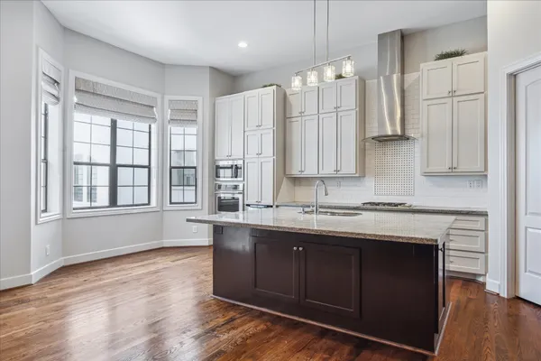 a kitchen with stainless steel appliances granite countertop a table chairs stove a refrigerator and cabinets