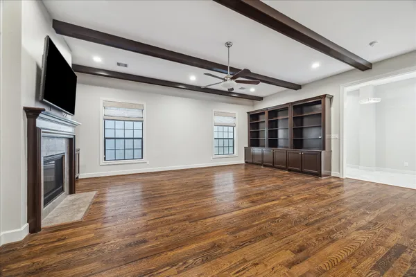 a view of an empty room with a fireplace and a window