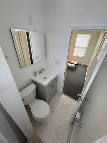 a bathroom with a toilet sink and mirror