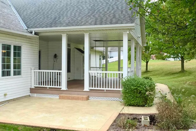 a view of a house with a small yard and a large tree