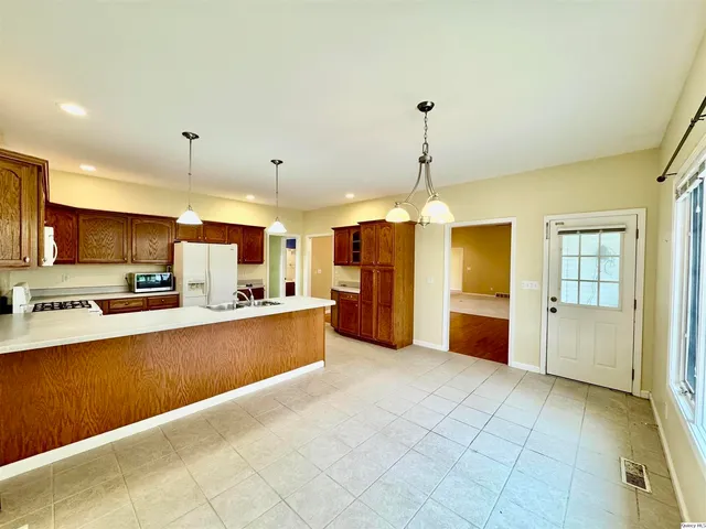 a large kitchen with kitchen island a sink stainless steel appliances and cabinets