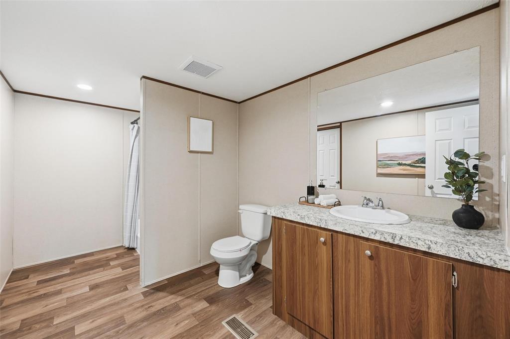 279 Carlisle Court Springtown, TX 76082 - Photo 11 of 22 a bathroom with a granite countertop sink toilet and mirror