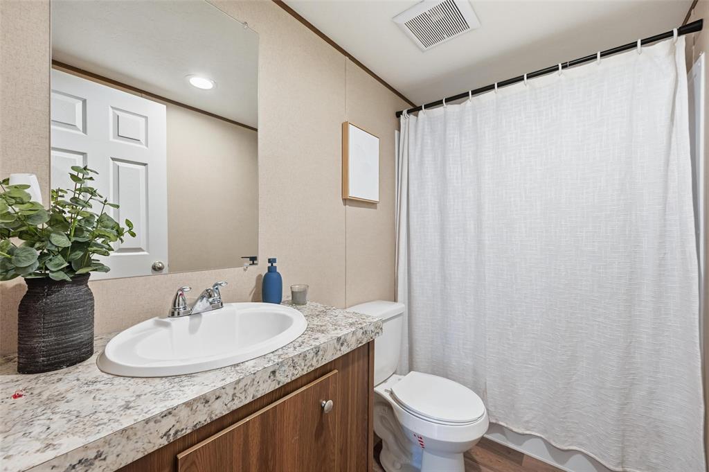 279 Carlisle Court Springtown, TX 76082 - Photo 16 of 22 a bathroom with a granite countertop sink and a mirror