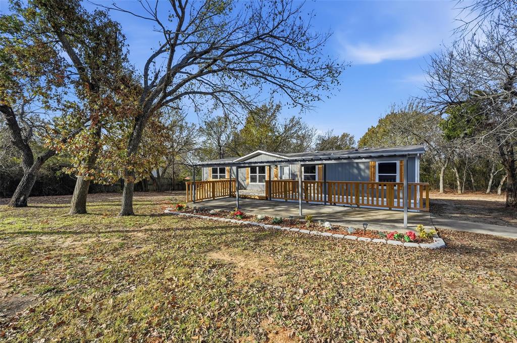 279 Carlisle Court Springtown, TX 76082 - Photo 2 of 22 a front view of a house with a garden