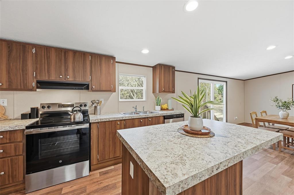 279 Carlisle Court Springtown, TX 76082 - Photo 6 of 22 a kitchen with a stove a sink and a refrigerator