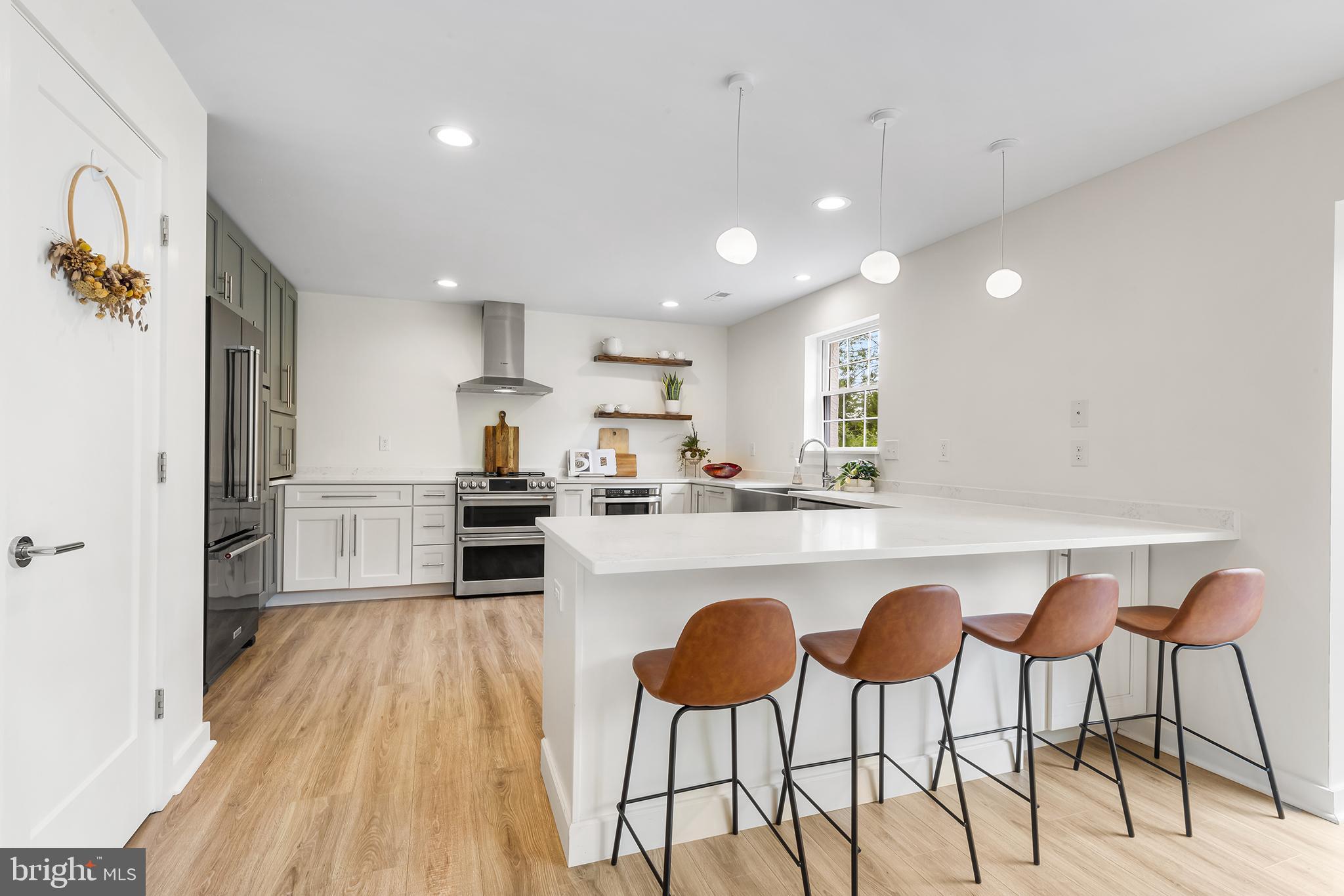 55 Dayleview Road Berwyn, PA 19312 - Photo 8 of 40 a kitchen with stainless steel appliances granite countertop a refrigerator a sink dishwasher a stove and white countertops with wooden floor