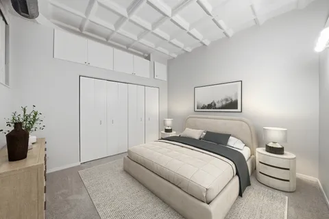 a bedroom with a bed and a potted plant