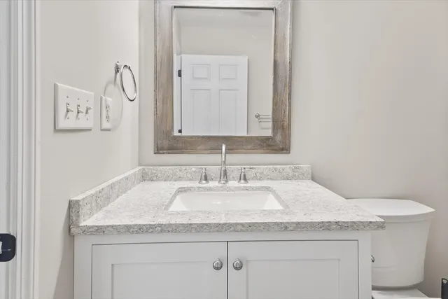 a bathroom with a granite countertop sink and a mirror