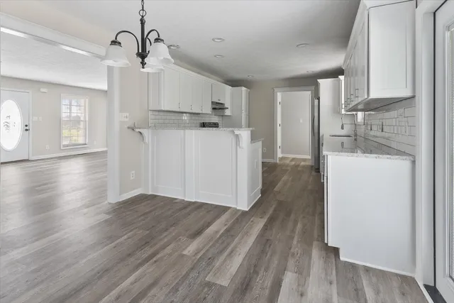 a view of a kitchen with wooden floor and a sink