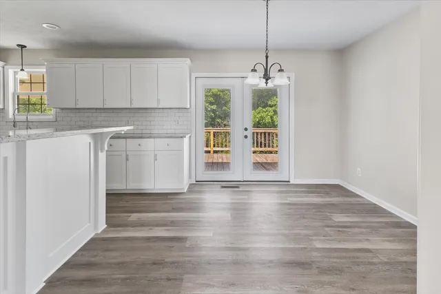 a view of a kitchen with wooden floor and a window