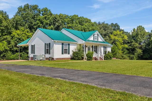 a front view of a house with a yard and trees