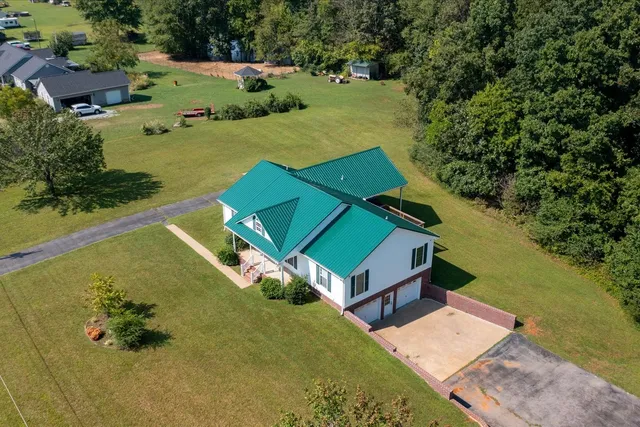 an aerial view of a house with swimming pool and ocean view