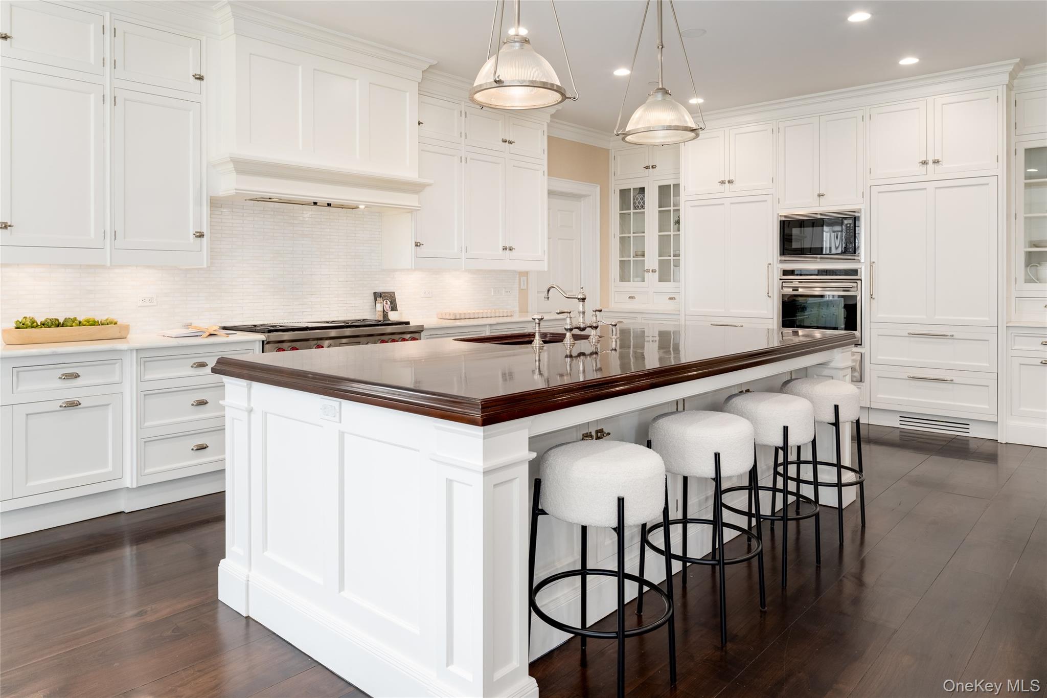 21 Dorann Road Purchase, NY 10577 - Photo 15 of 39 a kitchen with stainless steel appliances kitchen island granite countertop a table chairs sink and cabinets