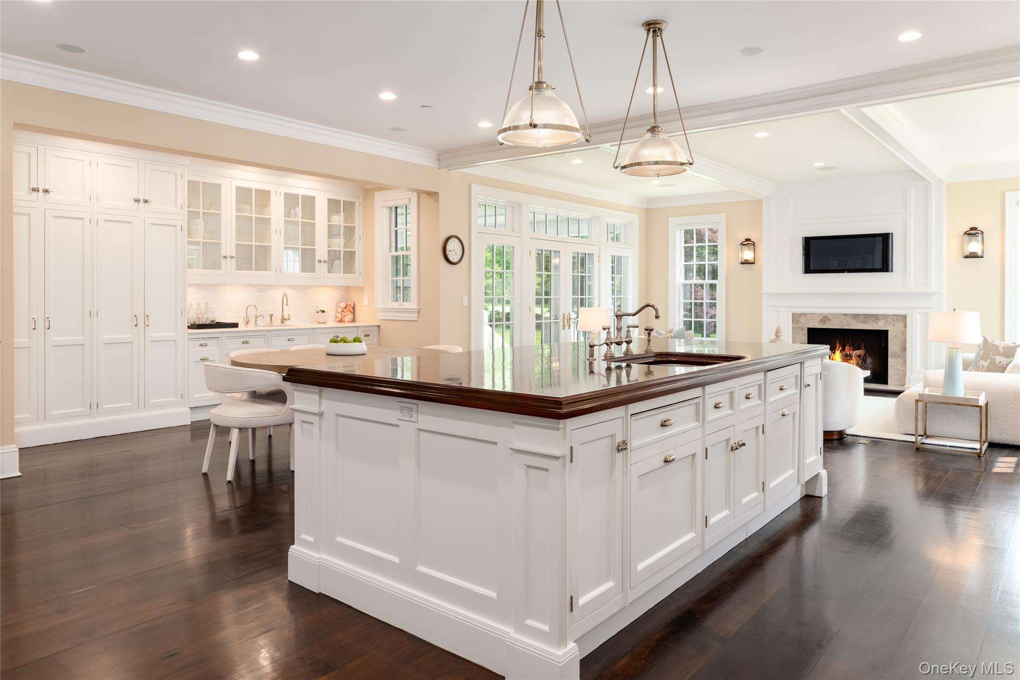 21 Dorann Road Purchase, NY 10577 - Photo 17 of 39 a large white kitchen with granite countertop a stove top oven a sink a dining table and chairs with wooden floor