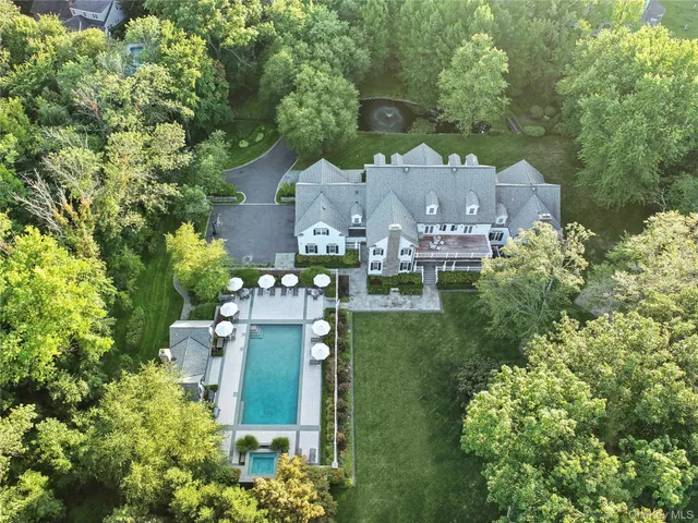an aerial view of a house with a yard and lake view