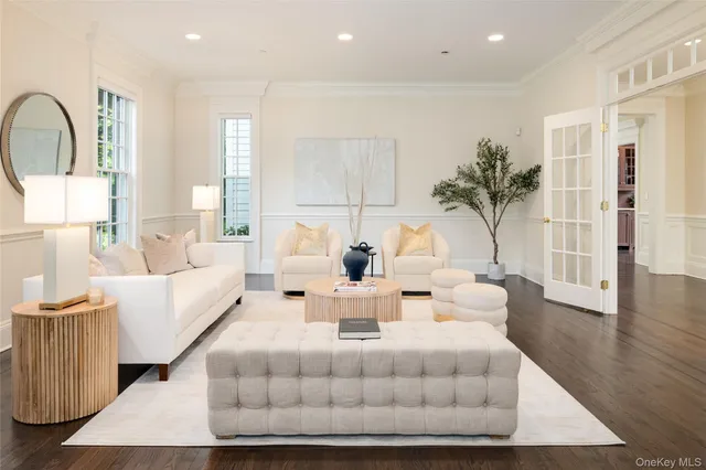 a living room with furniture a large window and wooden floor