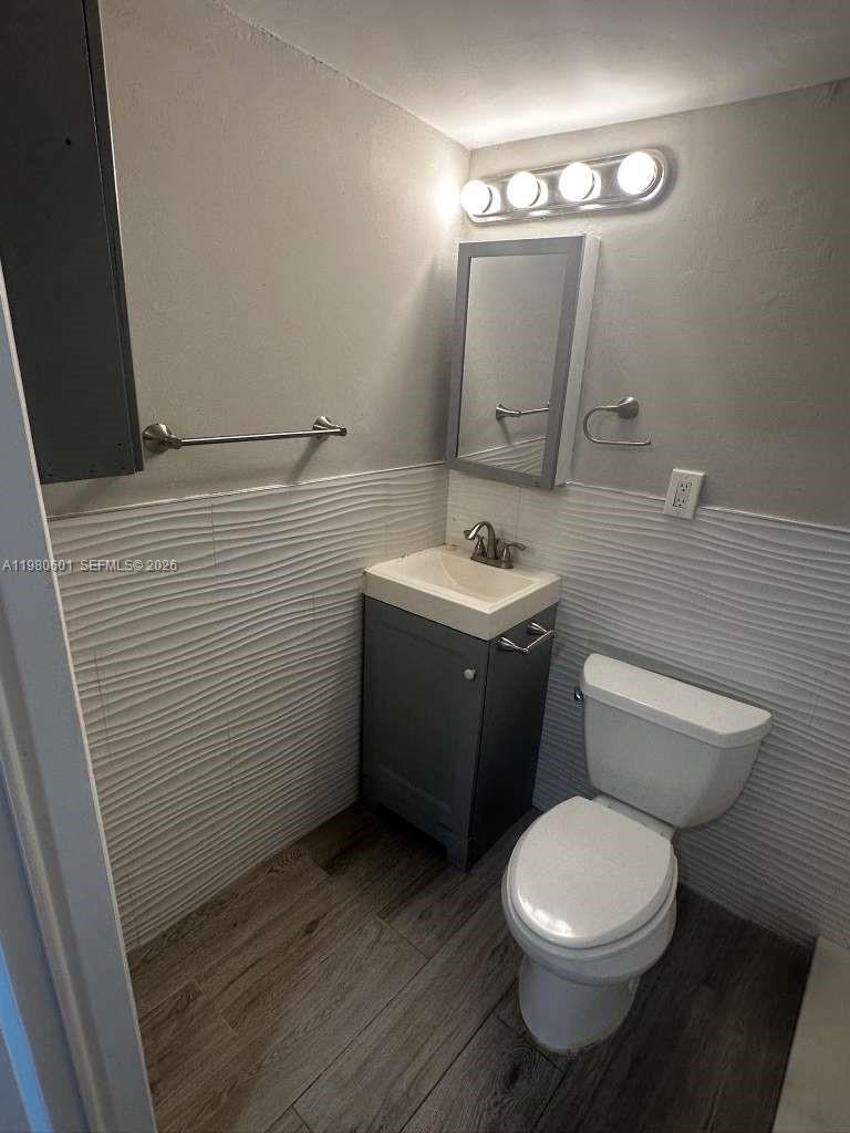 6837 Southwest 39th Terrace, Unit B Miami, FL 33155 - Photo 10 of 16 a bathroom with a toilet a sink and mirror