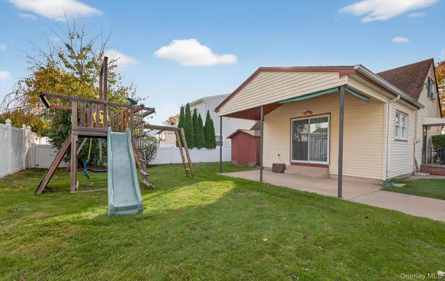 a view of a house with a yard and large trees