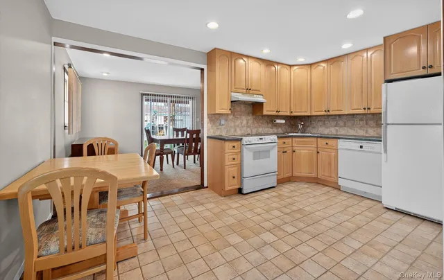 a kitchen with stainless steel appliances granite countertop a stove a sink a refrigerator and island