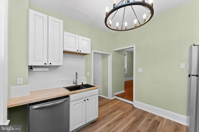 a kitchen with a sink cabinets and a wooden floor