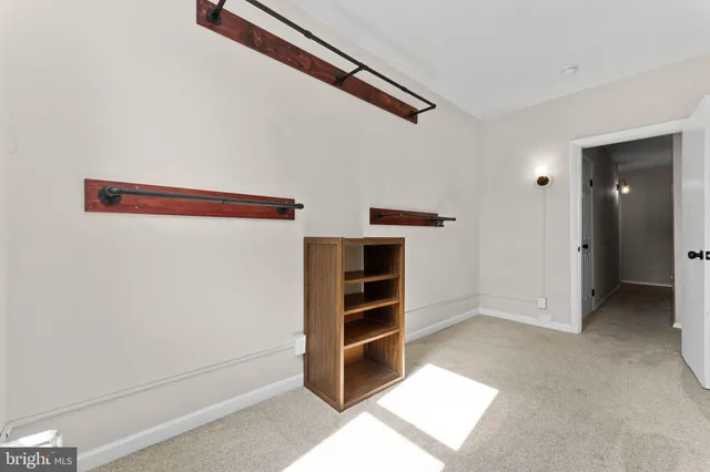 a view of an empty room with cabinet and stairs