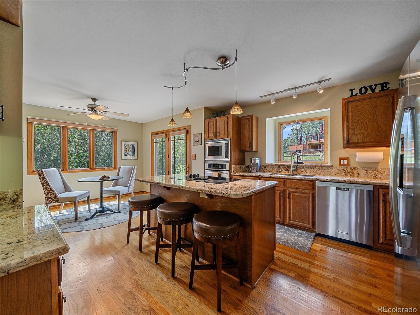 31412 North Bermuda Dunes Drive Evergreen, CO 80439 - Photo 13 of 46 a kitchen with stainless steel appliances granite countertop wooden floor and outdoor view