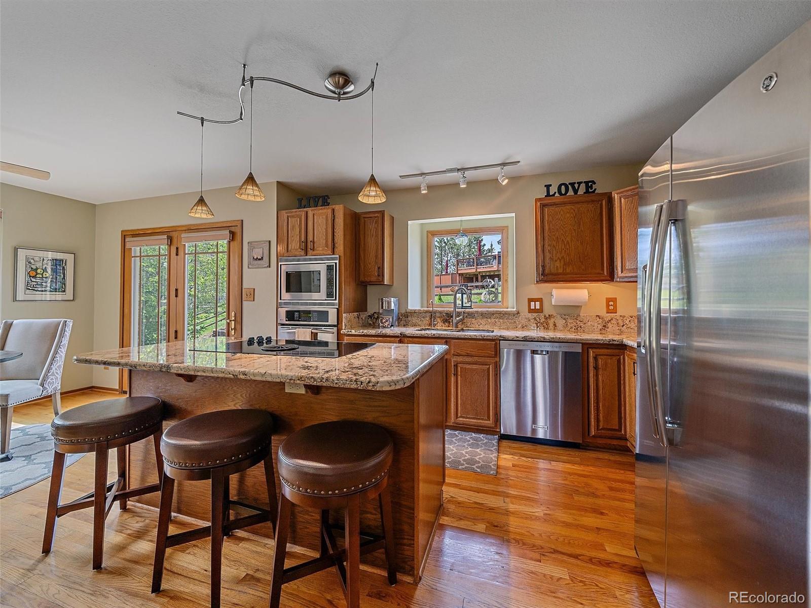 31412 North Bermuda Dunes Drive Evergreen, CO 80439 - Photo 14 of 46 a kitchen with granite countertop wooden floors and counter space
