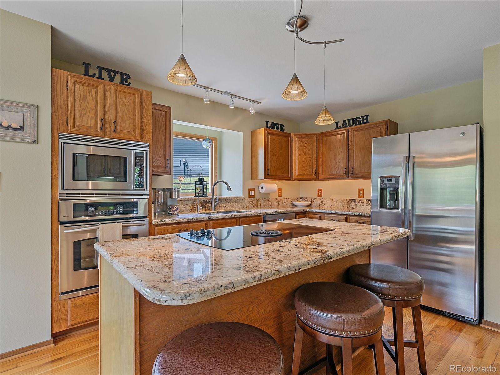 31412 North Bermuda Dunes Drive Evergreen, CO 80439 - Photo 15 of 46 a kitchen with granite countertop a stove refrigerator and microwave