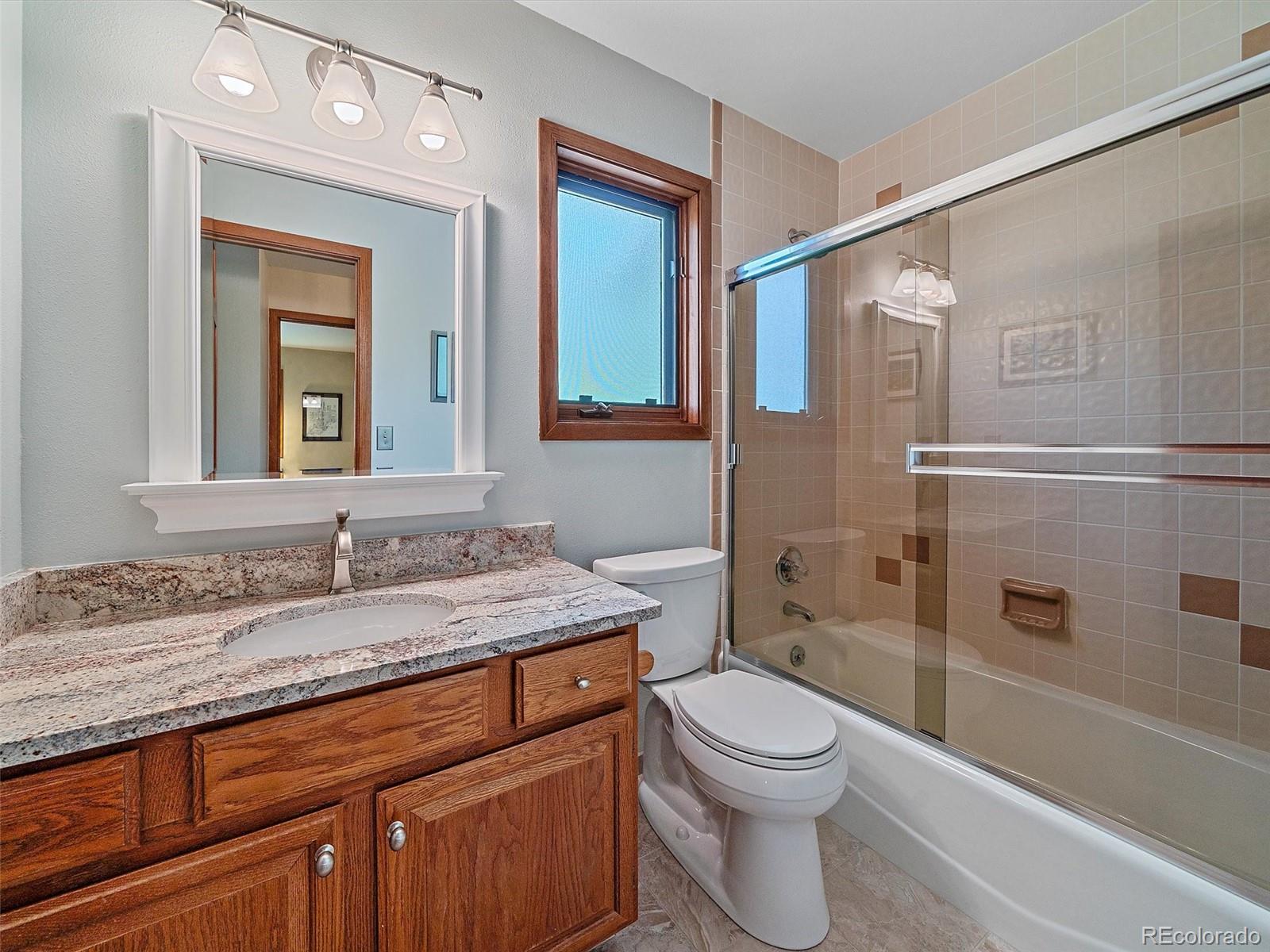 31412 North Bermuda Dunes Drive Evergreen, CO 80439 - Photo 32 of 46 a bathroom with a granite countertop toilet sink and mirror