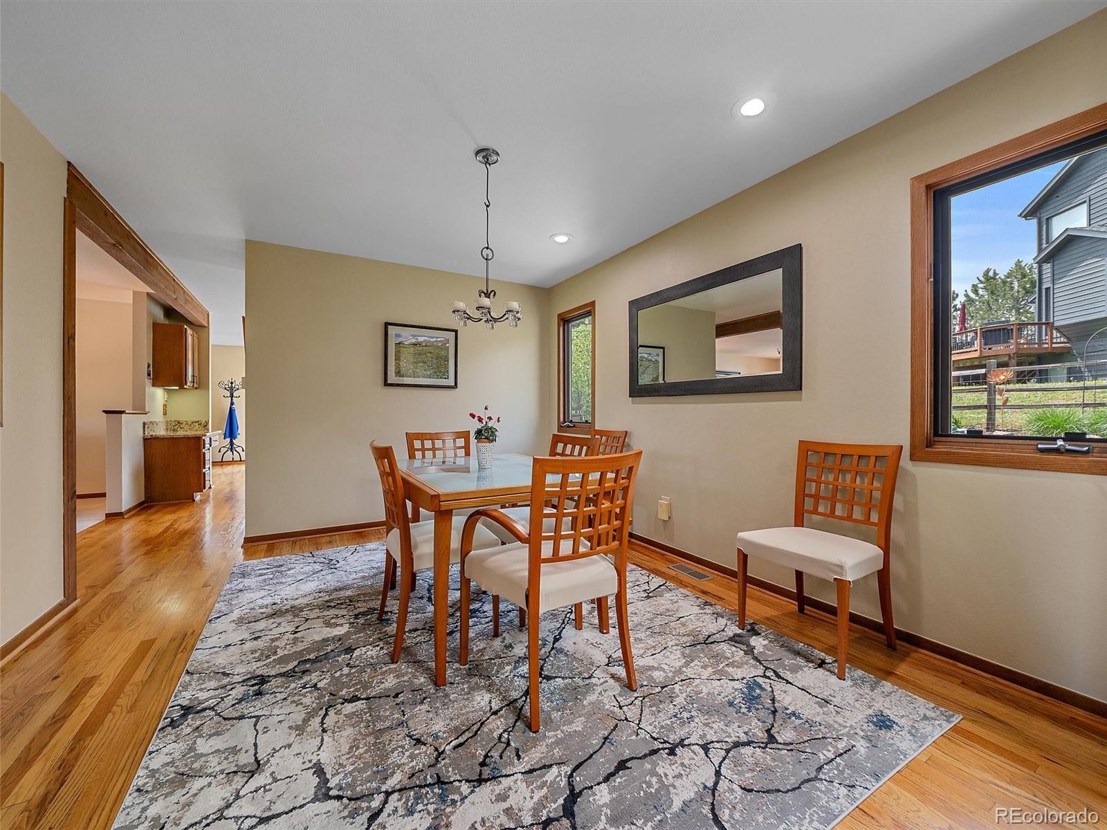 31412 North Bermuda Dunes Drive Evergreen, CO 80439 - Photo 8 of 46 a dining room with wooden floor and a chandelier