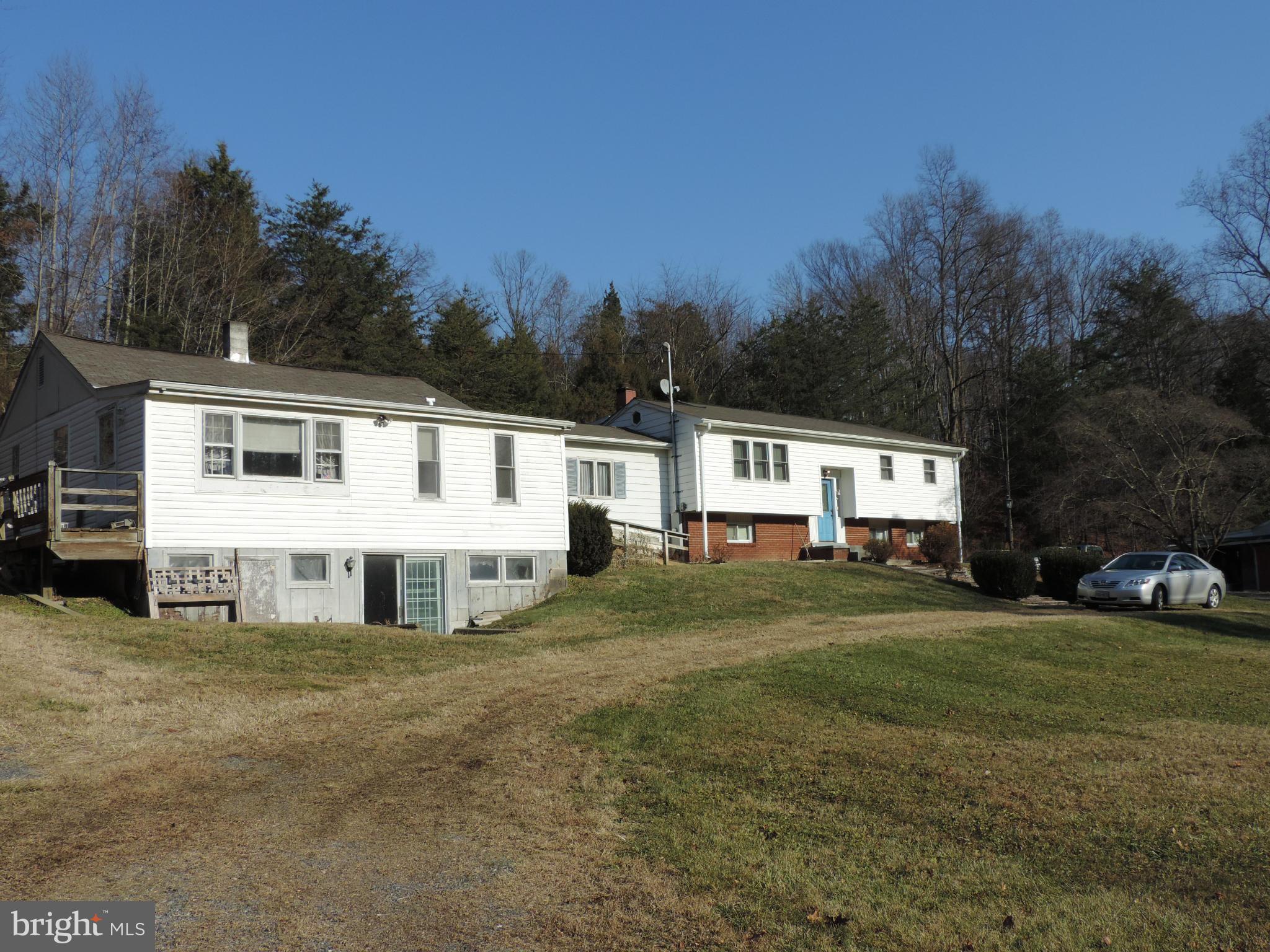 a view of a house with backyard and trees