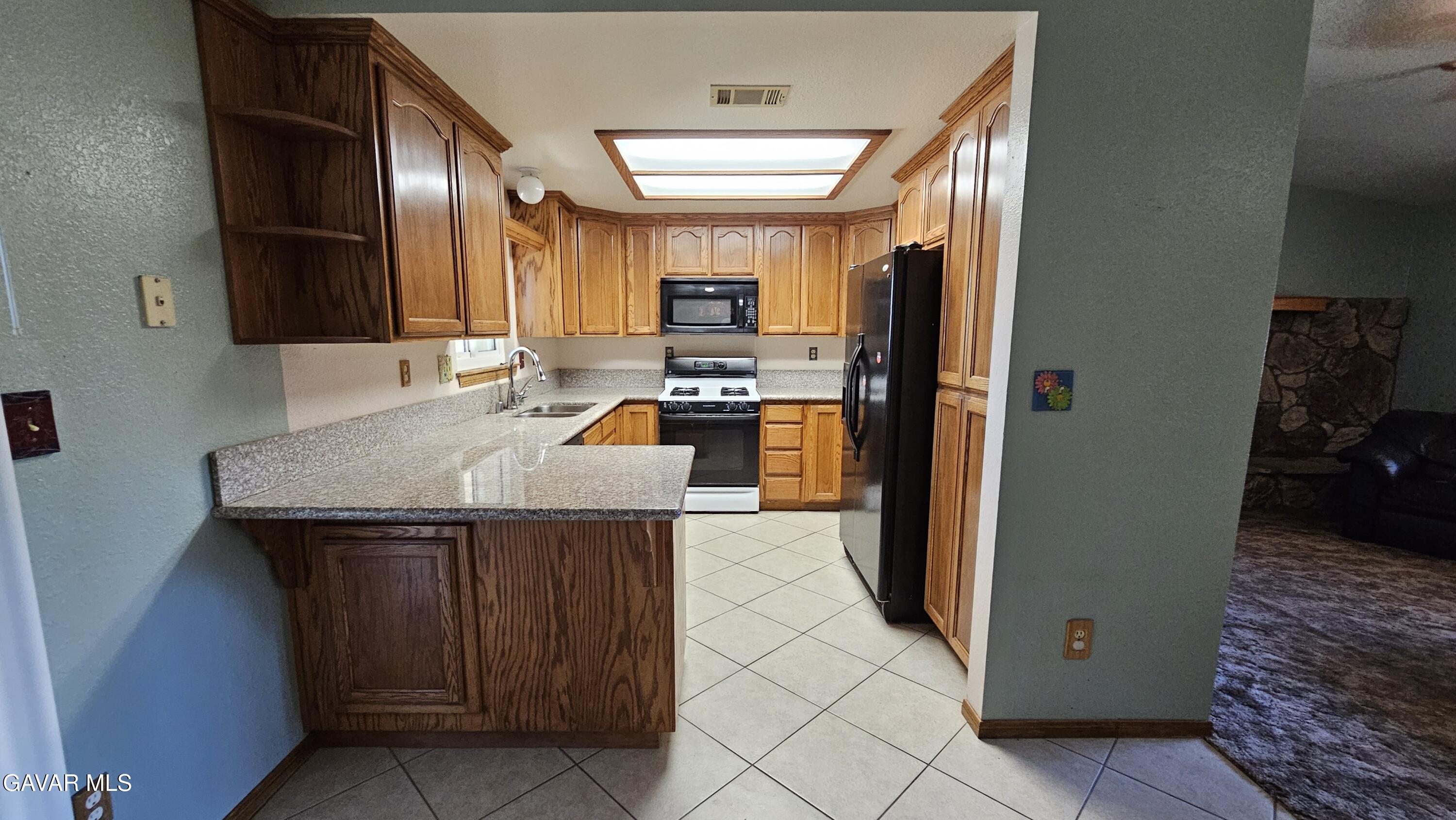 40985 174th Street East Lancaster, CA 93535 - Photo 19 of 33 a kitchen with stainless steel appliances granite countertop a refrigerator a stove and a sink