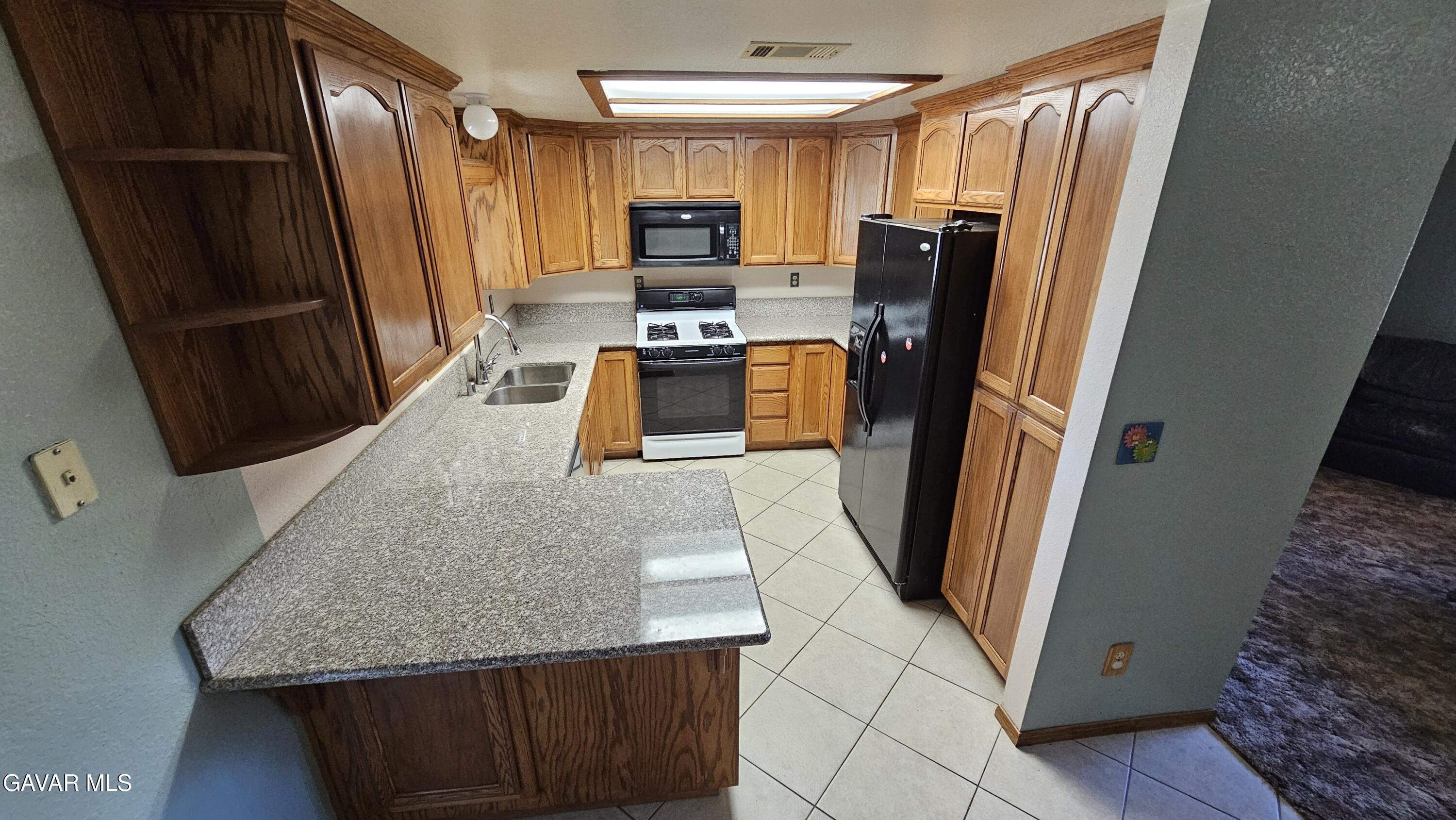 40985 174th Street East Lancaster, CA 93535 - Photo 20 of 33 a kitchen with stainless steel appliances granite countertop refrigerator stove and sink