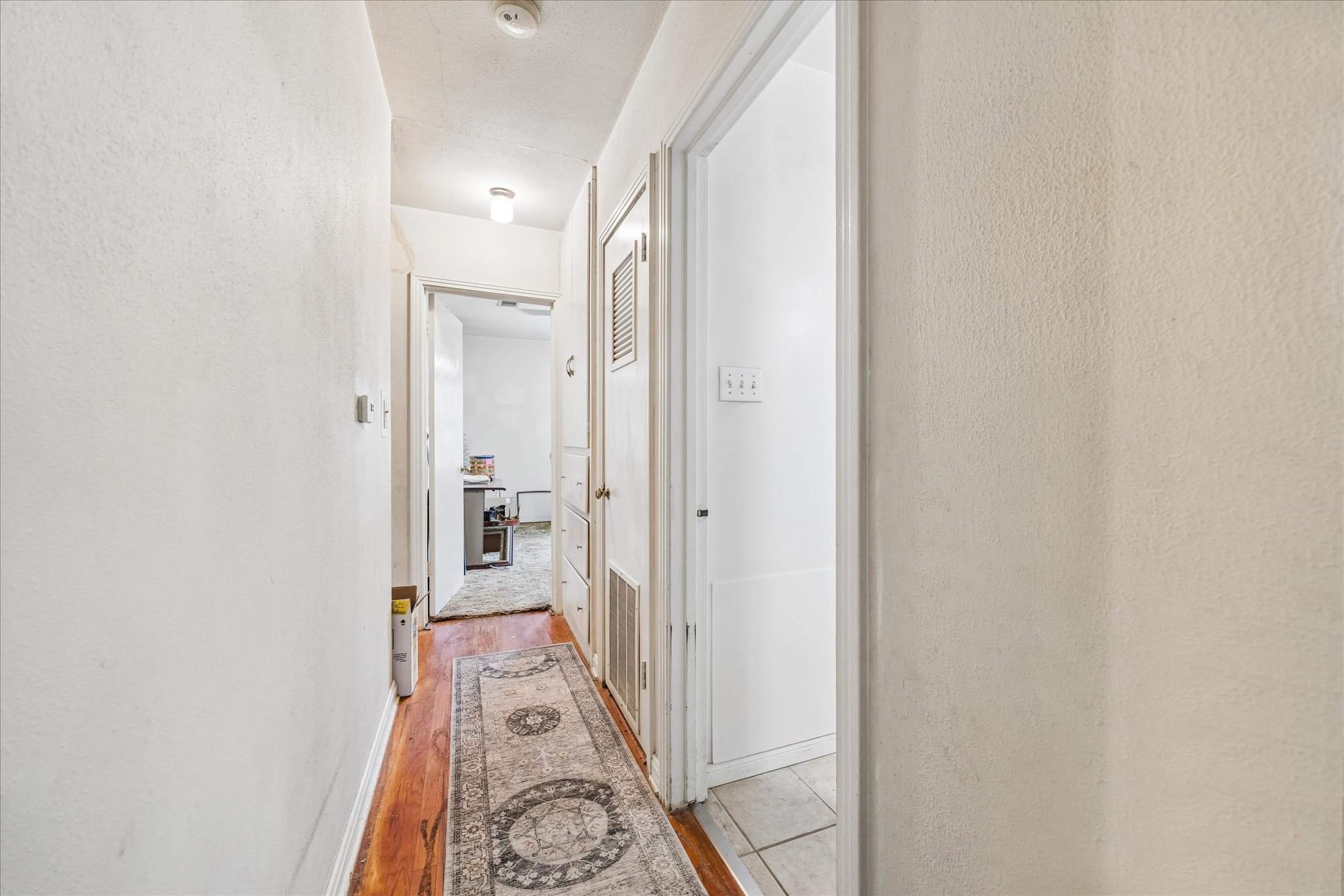 2009 Fort View Road Austin, TX 78704 - Photo 23 of 40 A classic hallway with warm hardwood flooring and crisp white walls leads to additional rooms.