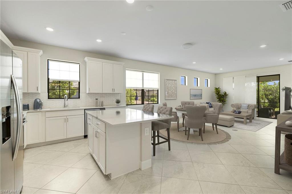 a large white dining hall with stainless steel appliances granite countertop furniture and a large window