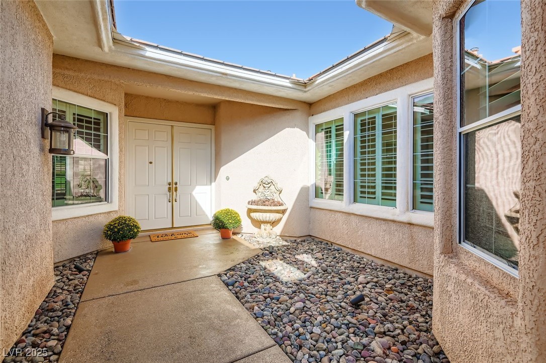 5015 Rivedro Street Las Vegas, NV 89135 - Photo 16 of 63 This additional view of the front courtyard showcases the welcoming entryway framed by elegant architectural details and the potential to add more lush landscaping. A perfect first impression that blends curb appeal with timeless design.
