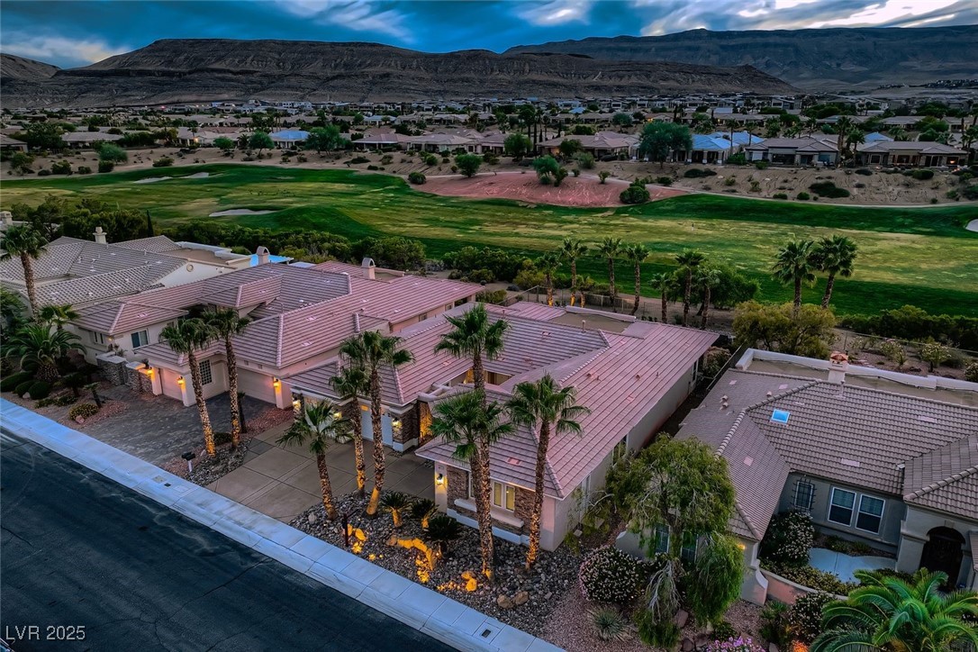 5015 Rivedro Street Las Vegas, NV 89135 - Photo 18 of 63 This elevated view captures the full breadth of the property from to the southwest, showcasing its expansive layout, manicured landscaping, and proximity to the 15th fairway of Siena Golf Club. The Sierra Nevada Mountains rise in the distance, framing the scene with natural grandeur.