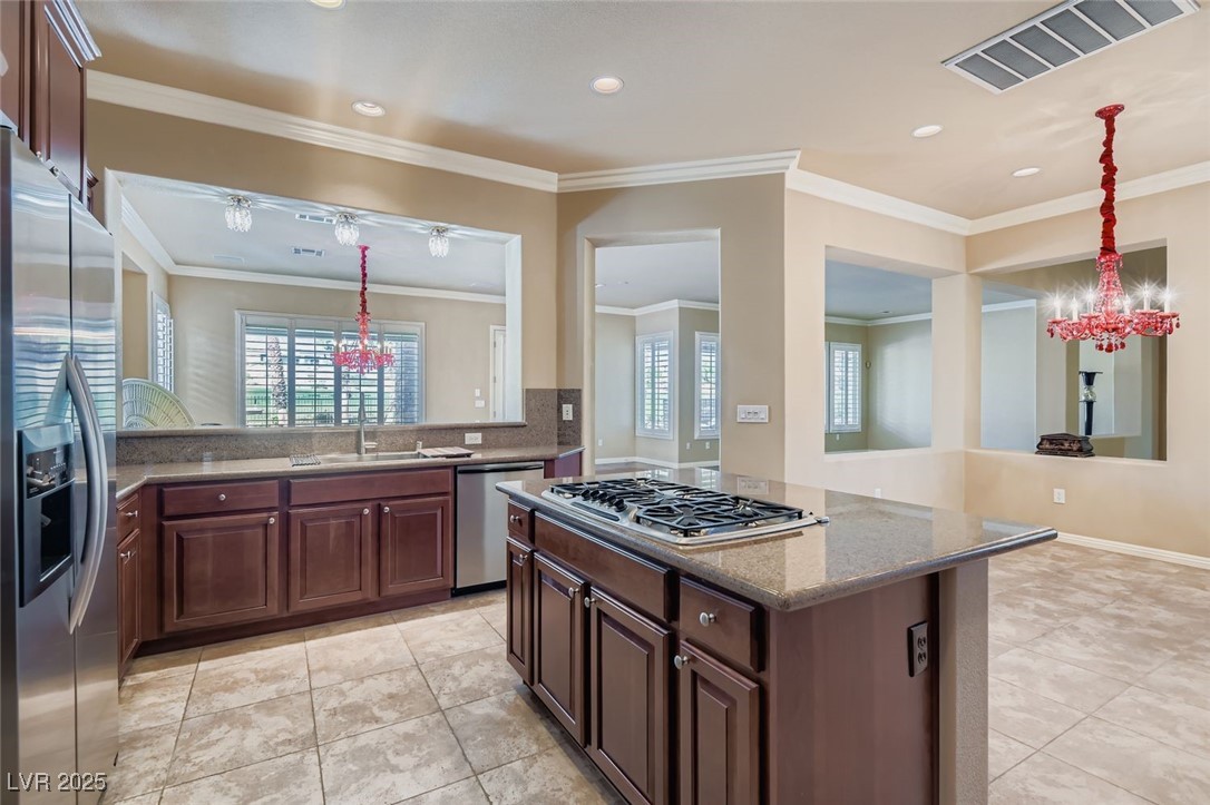 5015 Rivedro Street Las Vegas, NV 89135 - Photo 21 of 63 This view from the kitchen reveals a spacious living area perfect for entertaining or relaxing. To the right, a generous kitchen dining space offers room for gatherings, all framed by light tile flooring and elegant architectural details.