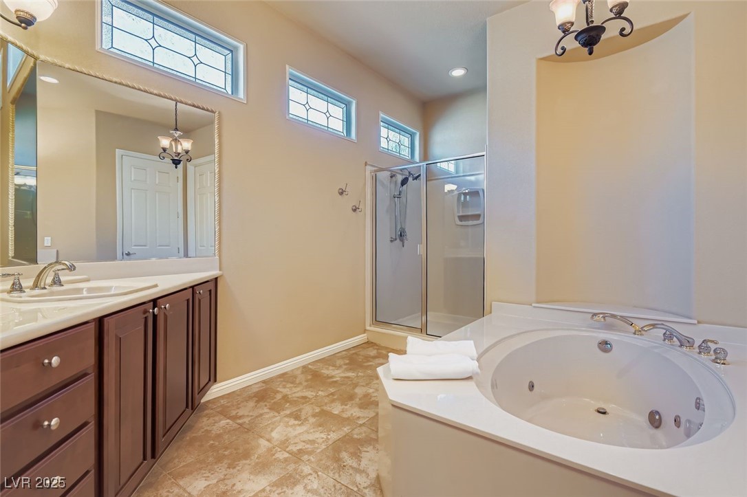 5015 Rivedro Street Las Vegas, NV 89135 - Photo 23 of 63 This elegant primary bath features dual sinks, a spacious shower stall, and a luxurious spa-style bathtub. Custom stained glass windows in the upper left corner add a touch of artistry and privacy, bathing the space in soft, natural light.