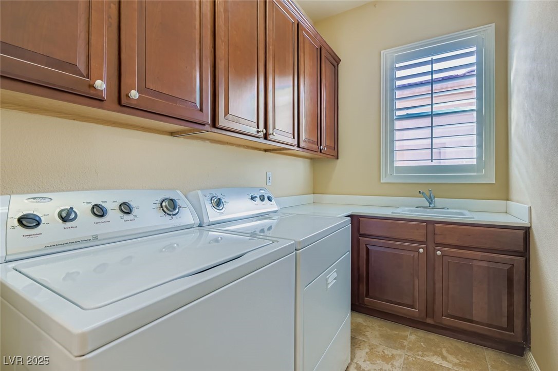 5015 Rivedro Street Las Vegas, NV 89135 - Photo 24 of 63 This well-equipped laundry area features a deep laundry sink, full-size washer and dryer, and an abundance of cabinetry for organized storage. A clean, efficient space designed to support everyday living with ease and elegance.