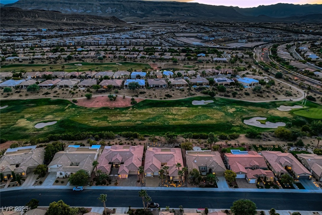 5015 Rivedro Street Las Vegas, NV 89135 - Photo 26 of 63 This elevated perspective captures the property’s western exposure, revealing its expansive footprint, manicured surroundings, and the dramatic sweep of the Sierra Nevada Mountains in the distance. A stunning visual that blends architectural presence with natural grandeur.