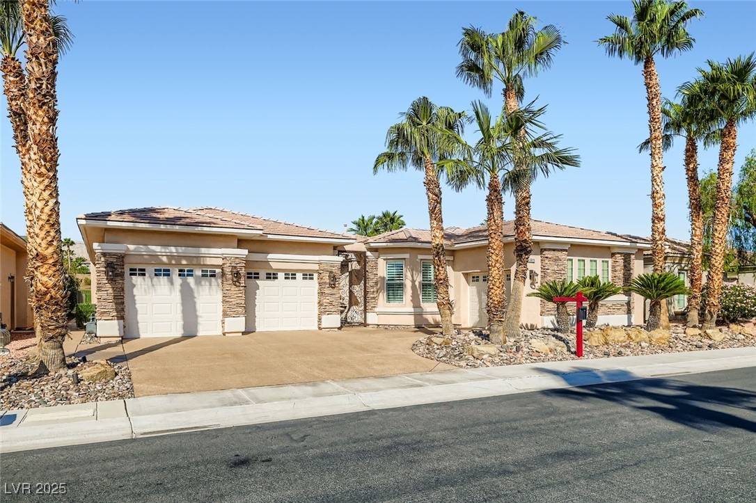 5015 Rivedro Street Las Vegas, NV 89135 - Photo 32 of 63 This beautifully crafted home features classic stucco siding, a tiled roof, and an attached 3 Car garage with a welcoming driveway. Thoughtfully landscaped with Wate-rSmart principles, the front yard blends desert charm with eco-conscious efficiency—perfectly complementing the home’s timeless curb appeal.