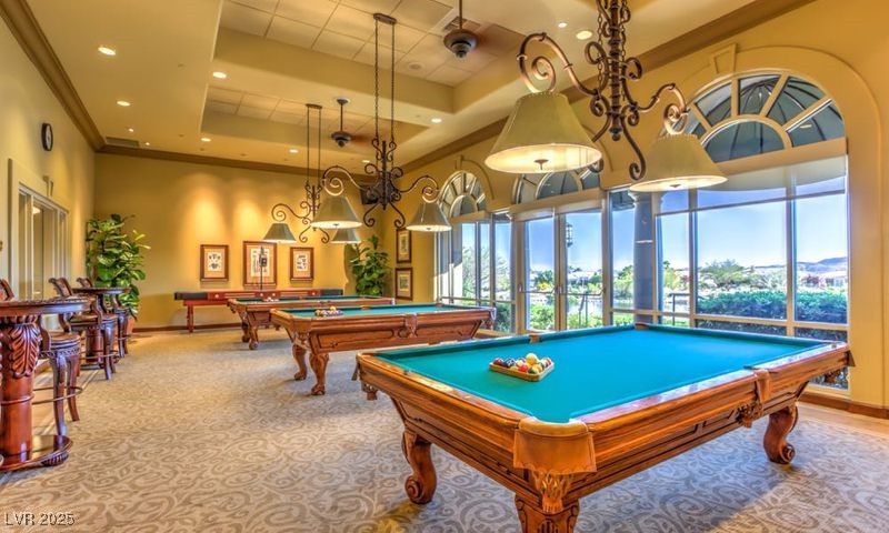 5015 Rivedro Street Las Vegas, NV 89135 - Photo 37 of 63 "The Game Room boasts a striking raised ceiling adorned with ornamental molding, creating an elegant yet inviting atmosphere. Equipped with billiards and bathed in natural sunlight, this space offers scenic views of the serene Lake Siena."